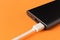 Black power Bank with adapter for charging mobile devices on a orange background