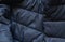 Black puffer jacket material as background closeup