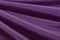 Black purple silk satin background. Copy space for text or product. Wavy soft folds on shiny fabric. Luxurious magenta background