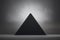 Black pyramid on grey background