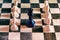 Black queen surrounded by white pawns on a chessboard