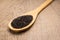 Black Quinoa seed. Spoon and grains over wooden table.