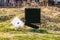 Black realtor`s sign with hanging name sign partly broken off and lot number 6 sign in rough grassy vacant lot for sale -