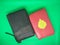 Black and red cover mushaf Al-Quran on green background