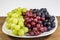 Black, red, green seedless grapes in a deep white bowl