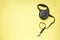 Black retractable dog leash on a yellow background, space for text, flat lay