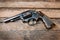 Black revolver gun with bullets isolated on wooden background