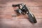 Black revolver gun with bullets on wooden background