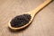 Black Rice seed. Spoon and grains over wooden table.