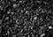 Black road stones gravel texture, rocks for construction, dark background of crushed granite gravel, small rocks, closeup