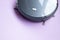 Black robot vacuum cleaner isolated on purple background
