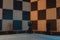 Black rook in the center of the wooden chessboard. Wooden chess piece in the center of a checkered pattern