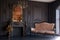 Black room interior with a vintage sofa, chandelier, mirror and fireplace