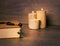 Black rosary and candle at wooden table