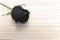 Black rose on wooden table, love concept for valentines