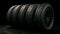 Black round car tires with rubber tread on alloy wheels. AI generated