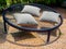 Black round macrame sofa bed on multiple ropes with three pillows in garden