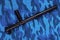 Black rubber baton on blue urban russian riot police camouflage flat lay