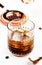 Black russian cocktail, trendy alcoholic drink with vodka, coffee liqueur and ice, white background, bar tools