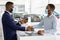 Black Salesman In Medical Mask Giving Key To Customer In Dealership Center