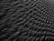 Black Sand dune. Black Sand beach macro photography. Background, texture, wave pattern of oceanic sand on the beach, black. Textur