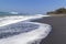 Black sand volcanic beach and white waves of ocean in Bali, Indonesia