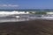 Black sand volcanic beach and white waves of ocean in Bali, Indonesia