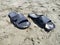 Black sandals flip-flops on the beach