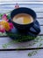 A black saucer with a cup of coffee on it and the inscription espresso on the cup