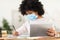 Black Schoolgirl Learning Using Digital Tablet, Wearing Mask Sitting Indoor