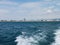 Black sea surface summer wave background. View from yacht. Exotic seascape with clouds and town on horizon. Sea nature tranquility