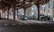 Black sedan drives under elevated tracks at Wabash and Adams, Ch