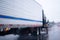 Black semi truck with reefer trailer on raining highway