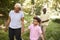 Black senior couple walking in forest with grandchildren