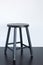 Black shabby stool on wooden surface