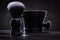 Black shaving brush with bowl on dark background close up view