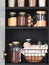 Black shelf in the kitchen with various cereals and seeds in glass jars