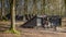 Black shelters are in the woods. homeless man`s bike stands in front of a shelter