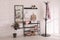 Black shelving unit with shoes and different accessories near white wall in hall. Storage idea