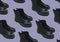 Black shiny polished black leather Marten boots shoes isolated on purple background. Fashionable punk historic British