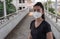 A Black shirt woman standing on putting on a respirator N95 mask to protect from airborne respiratory diseases as the flu covid-19