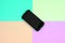 Black shock-proof smartphone lies on a pastel colored background