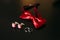 Black shoes of the groom, red bow tie, cufflinks, belt, on a bla