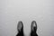 Black shoes standing on white wet floor