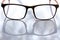 Black shortsighted or nearsighted eyeglasses on white acrylic table background, Close up & Macro shot, Reflection, Optical concept