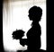 Black silhouette of beautiful bride with posy against white wind