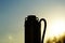 Black silhouette of a borehole pump on a sunset background. Submersible pump for wells in the shade