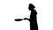 Black silhouette of chef girl frying pancakes on a pan.