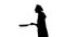 Black silhouette of a cook female is frying some pancakes.