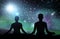 Black silhouette of couple meditating over space